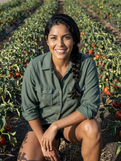 Ana, 35, Florida vegetable farmer kneeling in a tomato field in Collier County