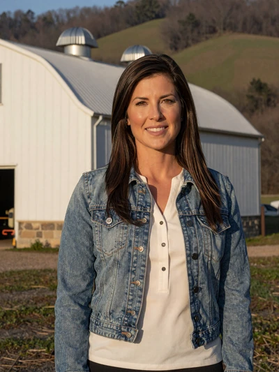 Jennifer, a 41-year-old poultry integrator standing beside a modern commercial poultry barn in Arkansas